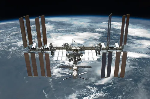 地球を背に飛ぶ国際宇宙ステーション